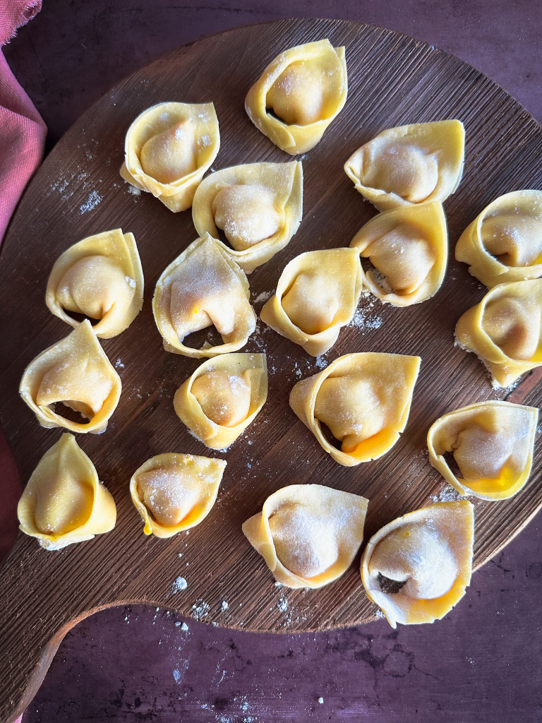 Tortelli di Zucca on a wooden tray