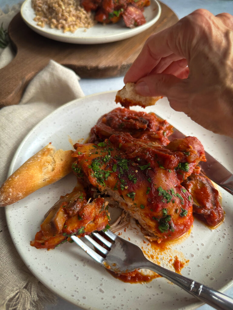 Hand dipping bread into sauce
