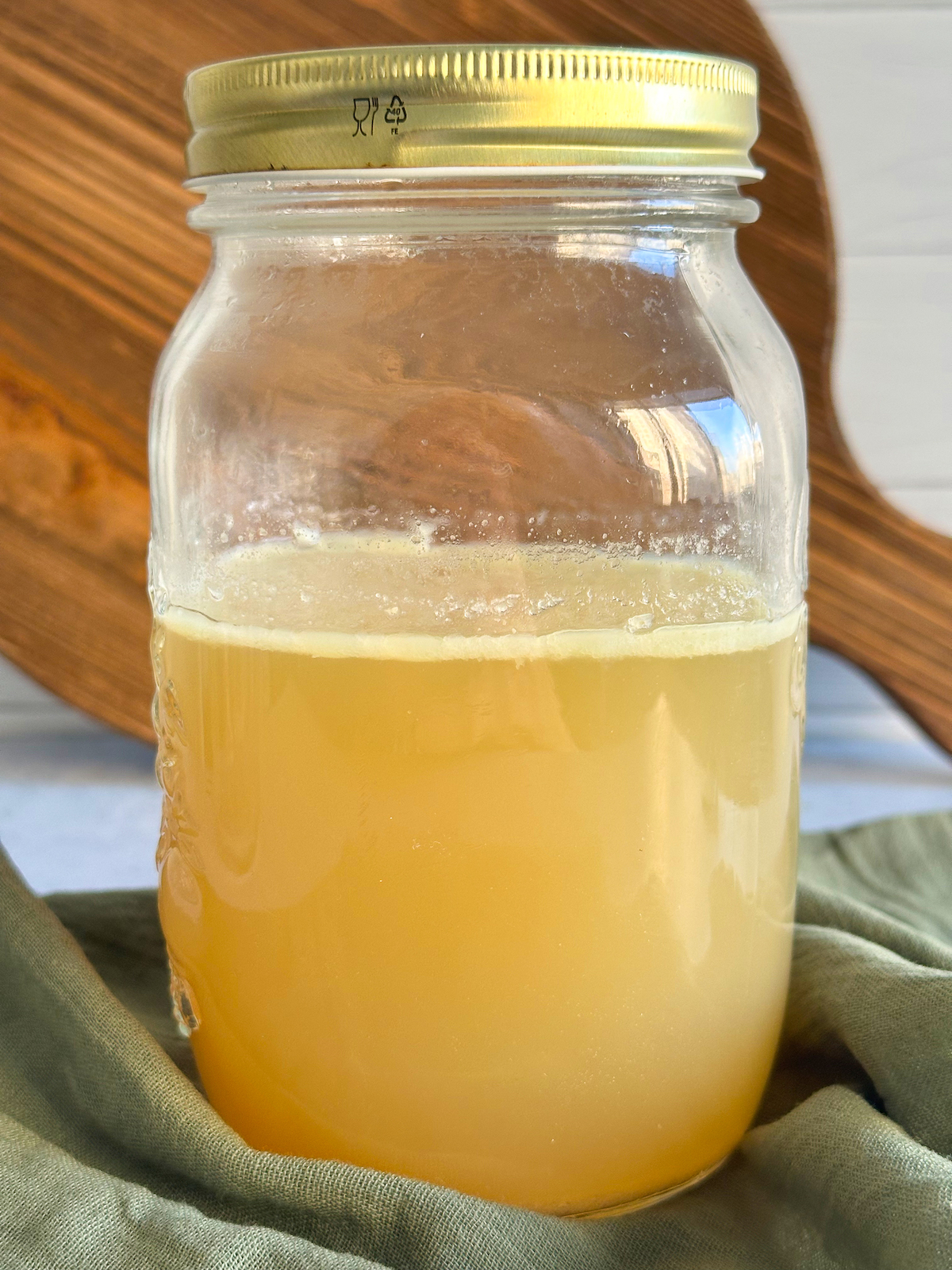 Golden chicken broth in jar after first removal of solid