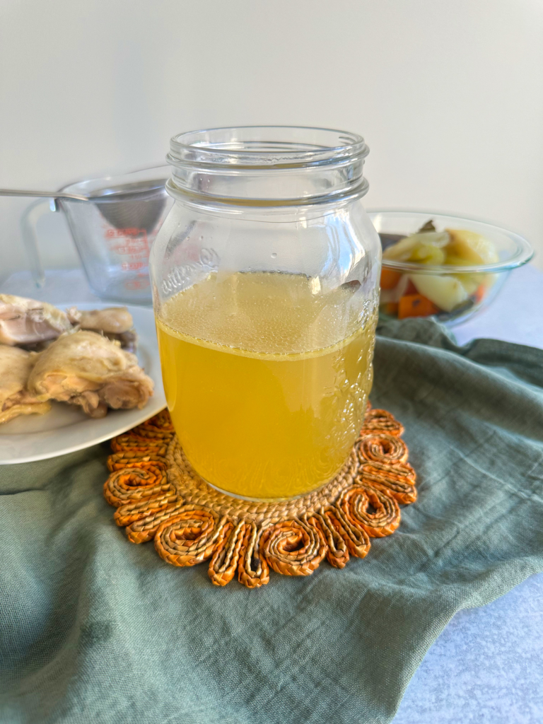 Golden chicken broth strained, with vegetables and boiled chicken.