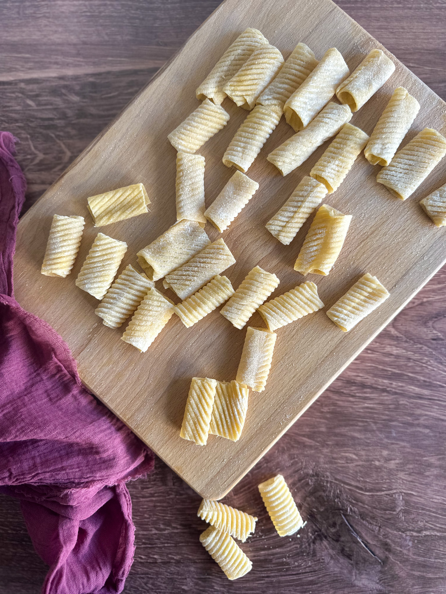 Homemade rigatoni pasta on a wood board