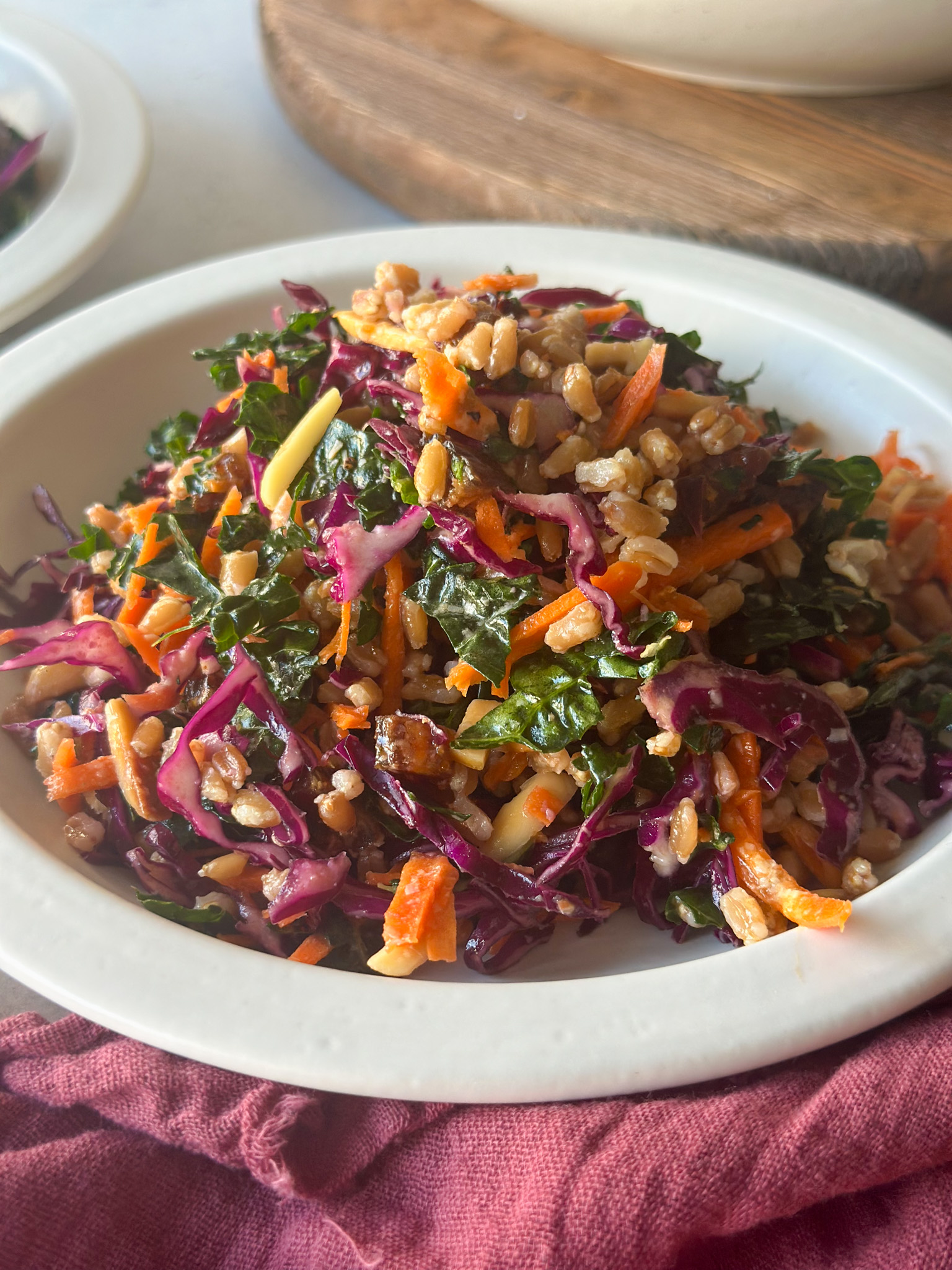 Winter Kale Salad in a white plate over a redish napkin